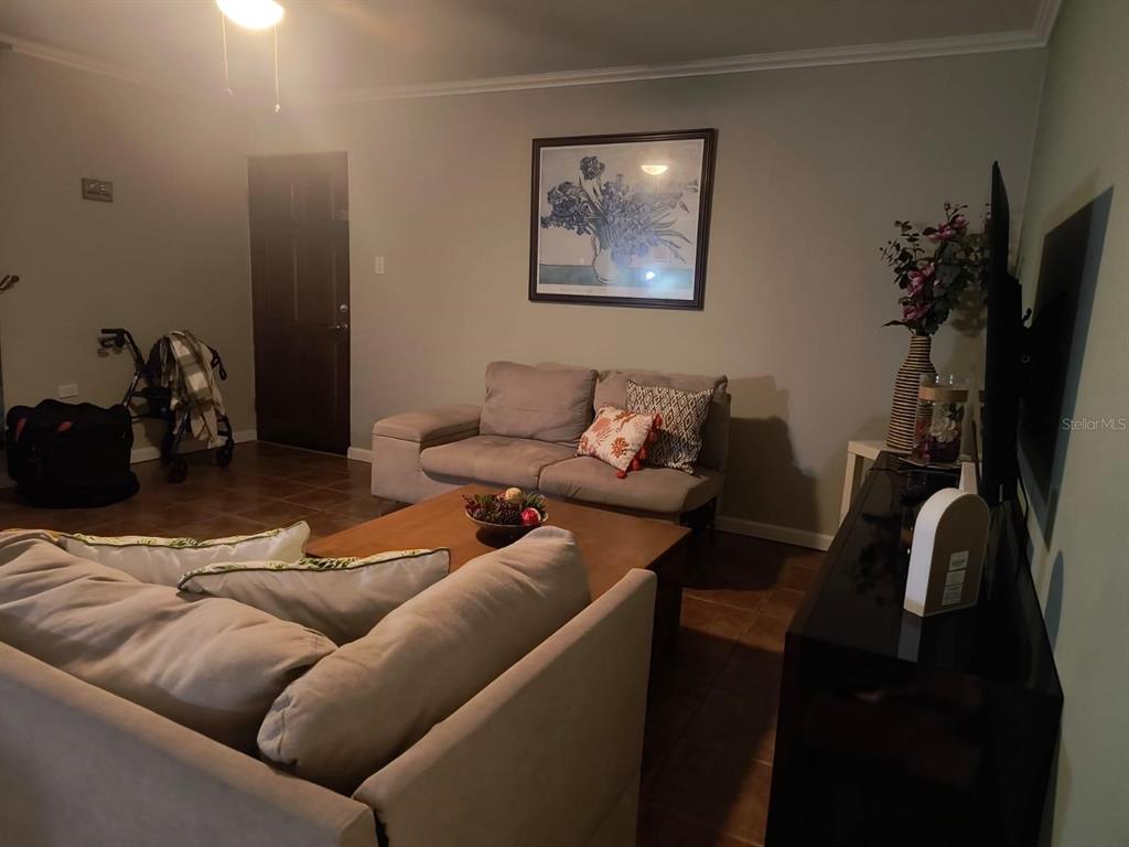 A living room features a beige sofa, a coffee table, and a wall-mounted television — FJQ2+FGJ MANUEL OTERO UNIT 3, VEGA BAJA, PR
