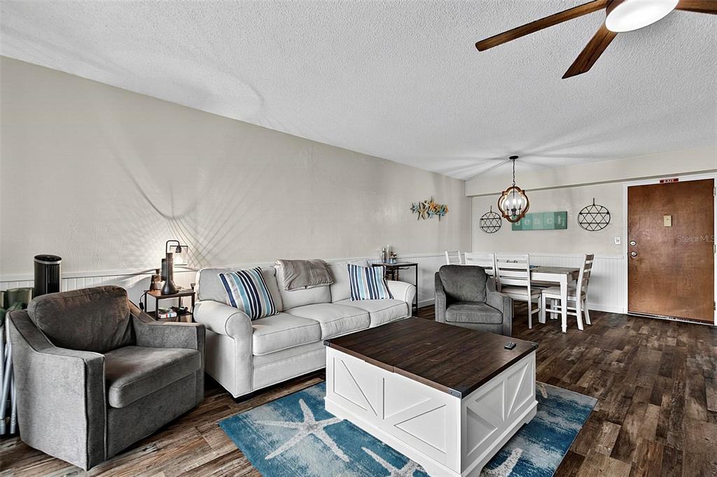 A living room features a white sofa, two gray armchairs, and a wood-topped coffee table — 3600 S OCEANSHORE BOULEVARD, FLAGLER BEACH, FL