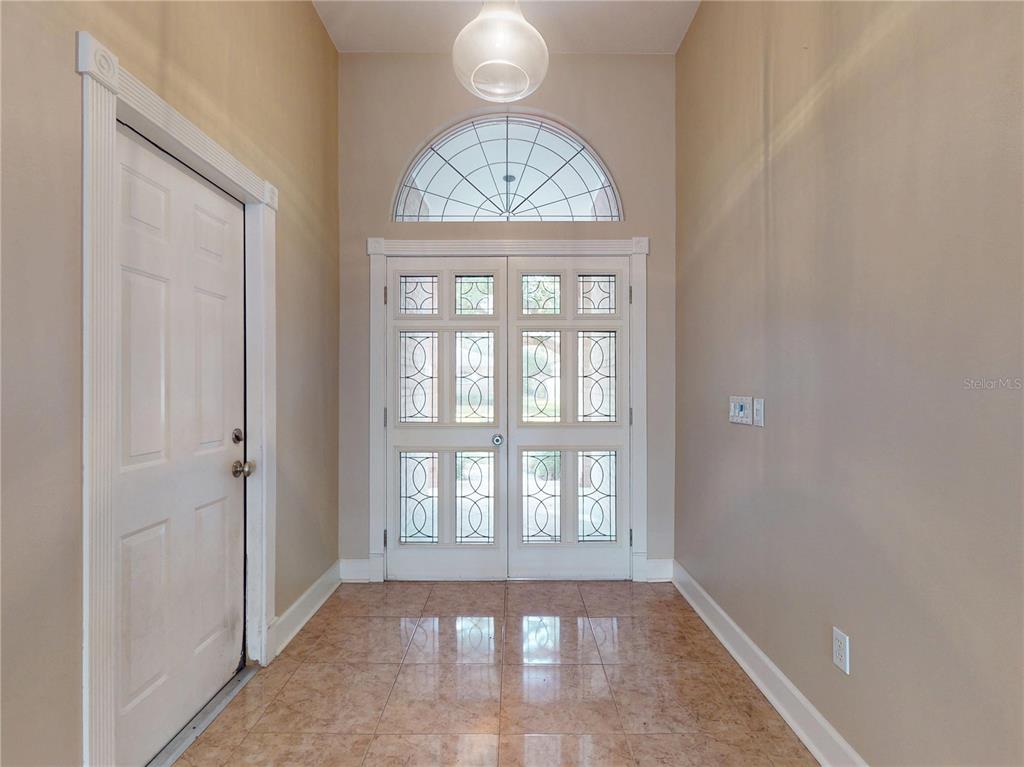 An entryway features a tiled floor, a double front door with glass panels, and a transom — 71 CARRIAGE CREEK WAY, ORMOND BEACH, FL
