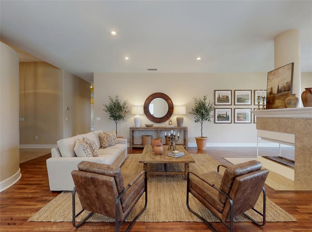 A living room features a sofa, two leather armchairs, a coffee table, and a fireplace — 71 CARRIAGE CREEK WAY, ORMOND BEACH, FL