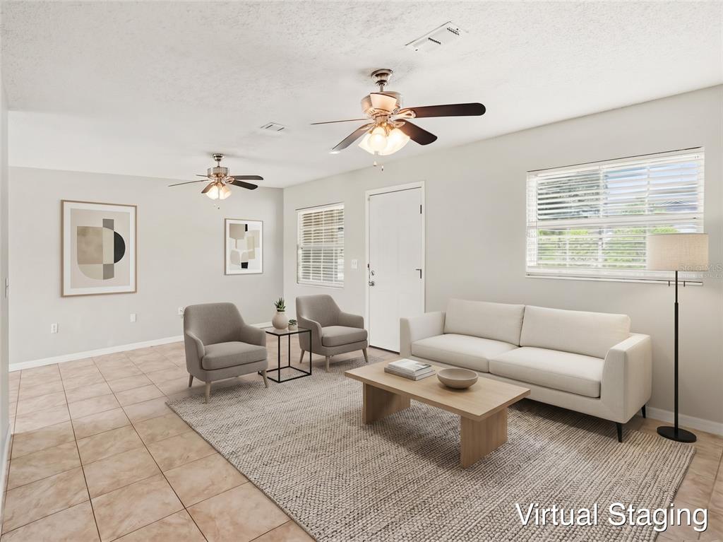 An empty room with tiled floors, two ceiling fans, a white door, and two windows — 3255 KELVINGTON DRIVE, ORLANDO, FL