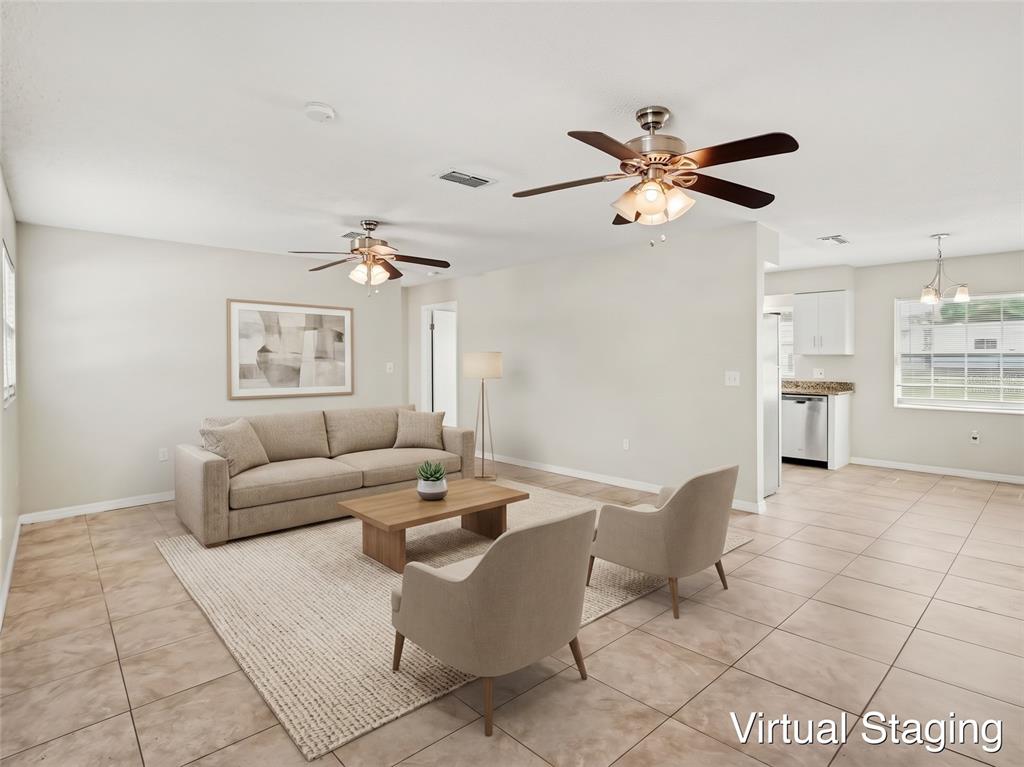 A kitchen features white cabinets, granite countertops, stainless steel appliances, and tile flooring — 3255 KELVINGTON DRIVE, ORLANDO, FL