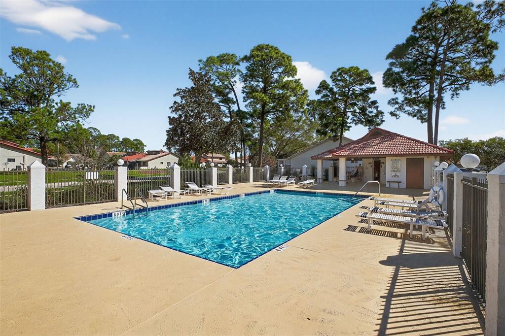 A rectangular outdoor swimming pool with a surrounding deck and a small covered pavilion — 3559 FOREST BRANCH DRIVE Apt E, PORT ORANGE, FL