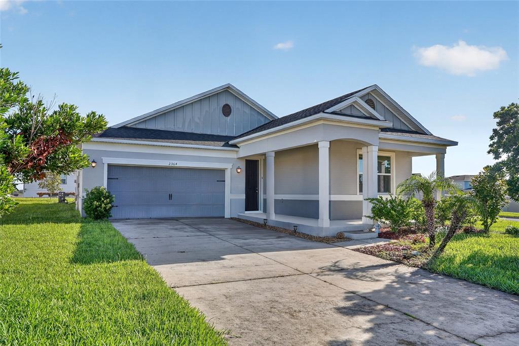 An aerial view of a single-story suburban house with a gray roof and driveway — 2364 CARRIAGE POINTE LOOP, APOPKA, FL