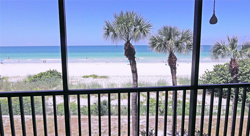 A screened balcony features a dining set and lounge chair overlooking a beach at sunset — 900 GULF BOULEVARD UNIT 302, INDIAN ROCKS BEACH, FL