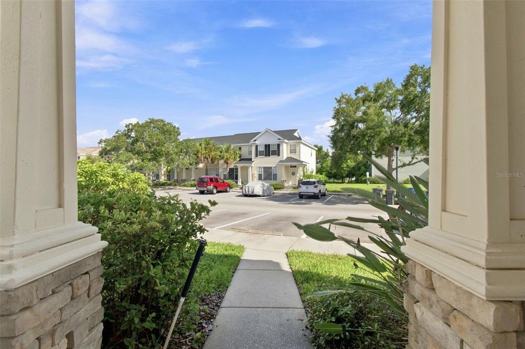 A view from a covered porch looking out toward a parking lot and townhouses — 12225 COUNTRY WHITE CIRCLE, TAMPA, FL