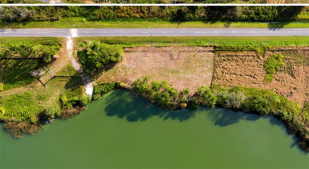 An aerial view shows a cleared rectangular plot of land adjacent to a lake and road — 1380 OLD BREWSTER ROAD, FORT MEADE, FL