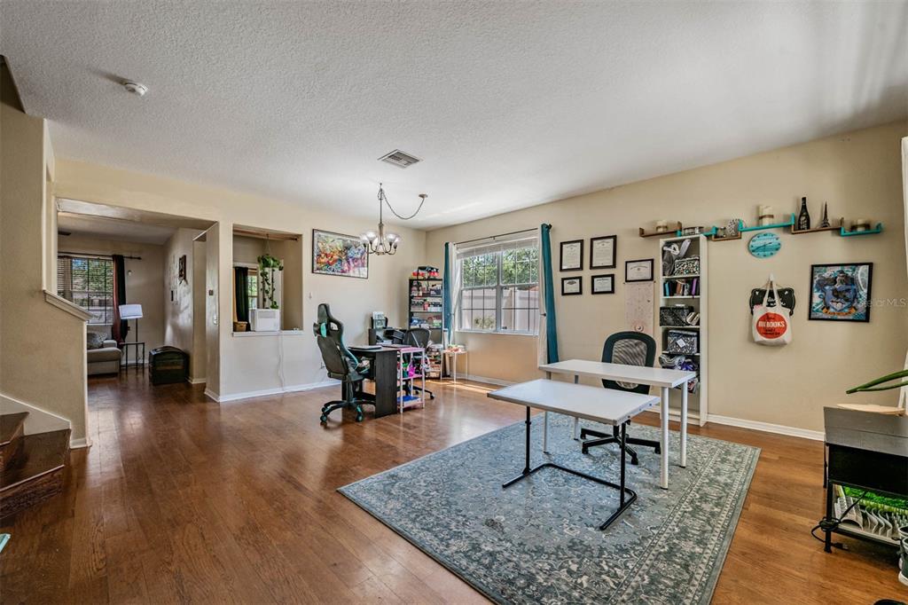 A home office with wood flooring, a large area rug, and multiple desks and shelves — 10945 SUBTLE TRAIL DRIVE, RIVERVIEW, FL