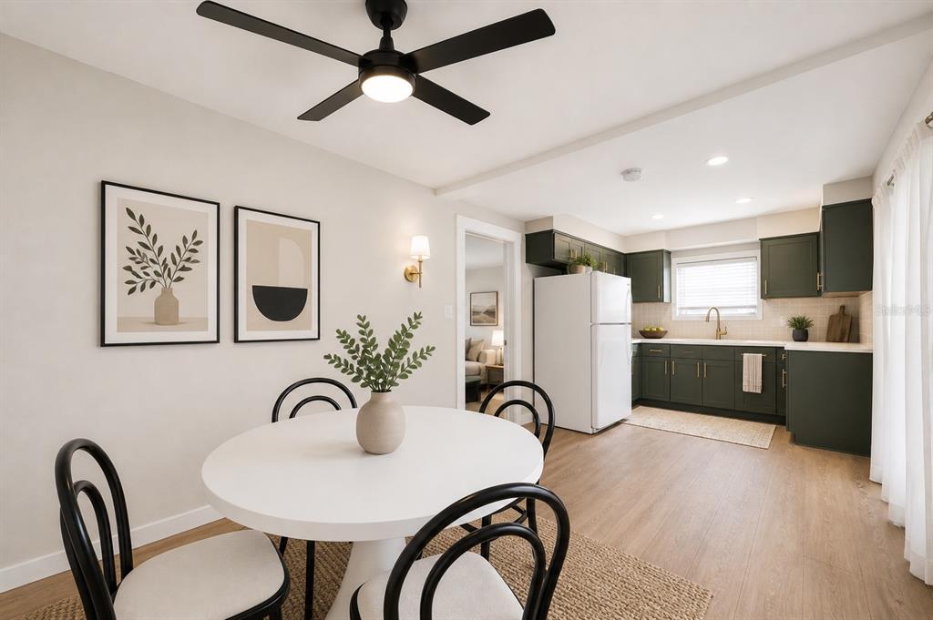 A dining area with a round table and black chairs sits beside a green kitchen — 531 ATHENS STREET, TARPON SPRINGS, FL