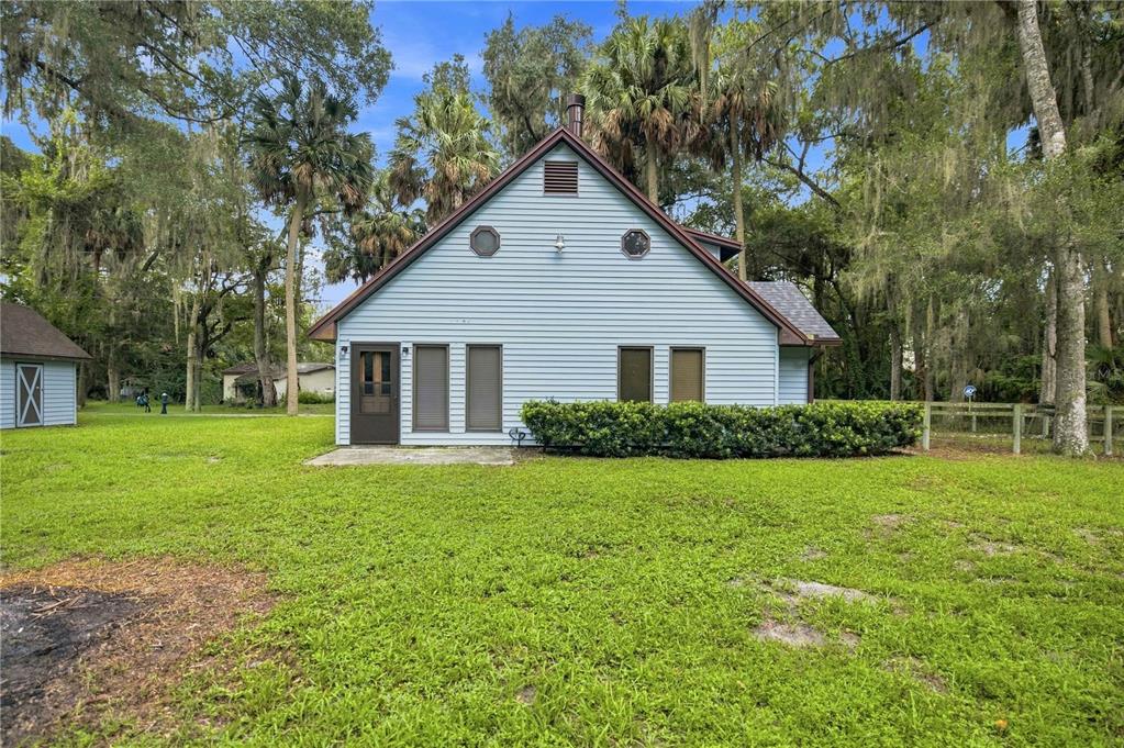 A light blue house with a gabled roof stands on a grassy lot with trees — 3580 NE 160TH LANE, CITRA, FL