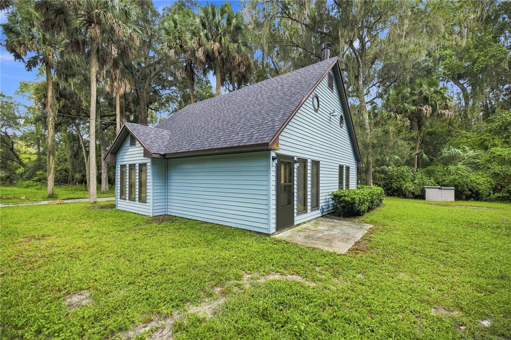 A light blue, two-story house with a dark shingled roof stands in a grassy yard — 3580 NE 160TH LANE, CITRA, FL