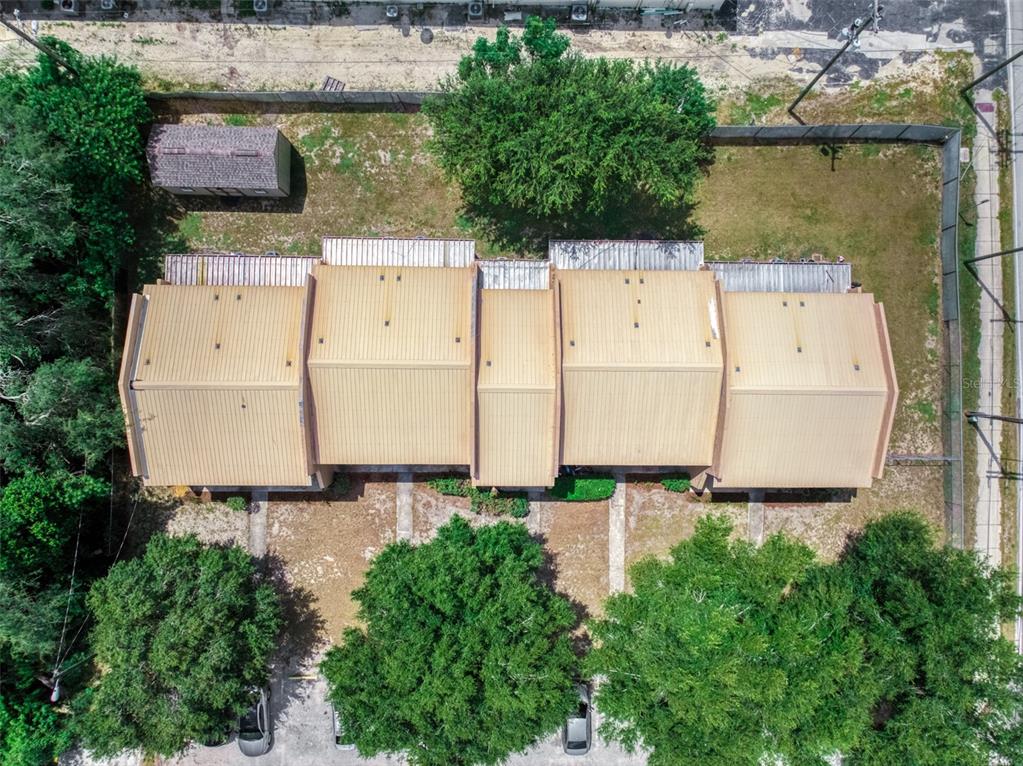 An aerial view shows a multi-unit residential building with metal roofs and surrounding trees — 1001 S LAKE ANOKA BOULEVARD, AVON PARK, FL