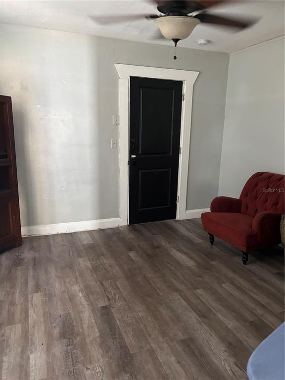 A room with gray walls, wood-look flooring, a black door, and a red armchair — 611 N LINCOLN AVENUE, LAKELAND, FL