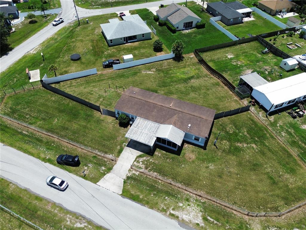 An aerial view shows a single-story house with a metal carport and a fenced yard — 4300 MEADOW RIDGE AVENUE, MULBERRY, FL
