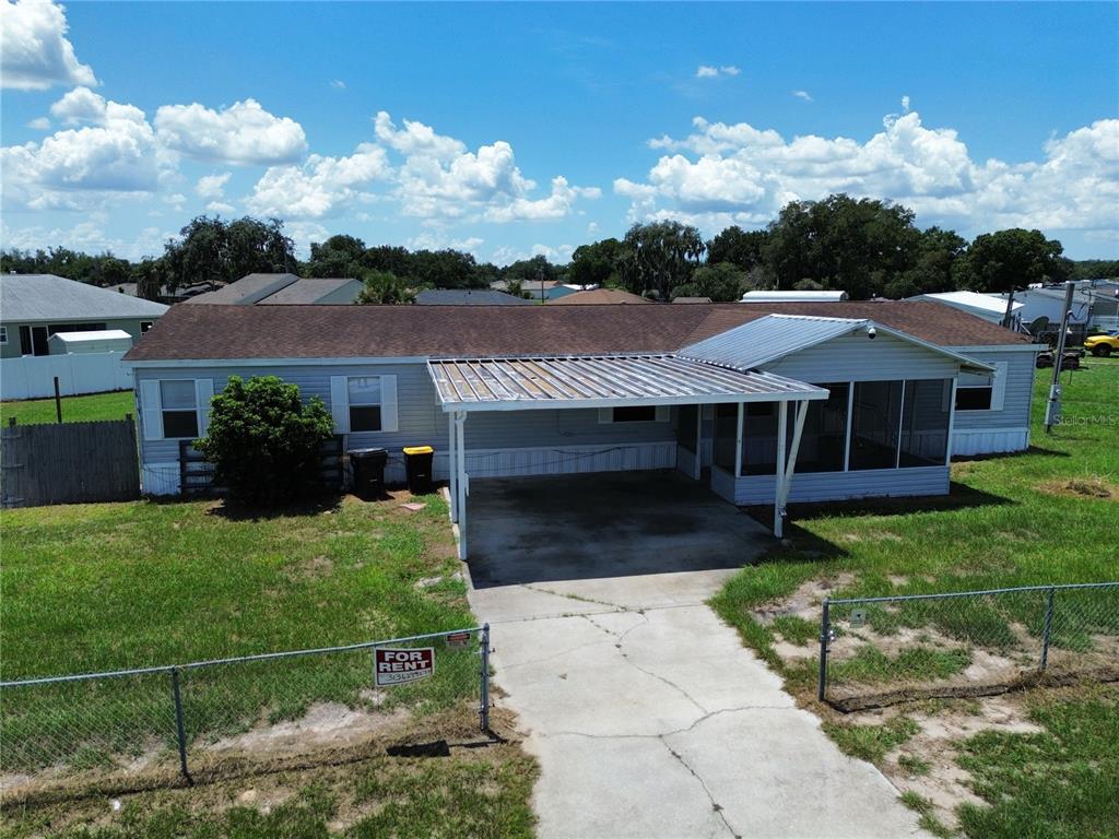 An aerial view shows a single-story house with a metal carport and a fenced yard — 4300 MEADOW RIDGE AVENUE, MULBERRY, FL