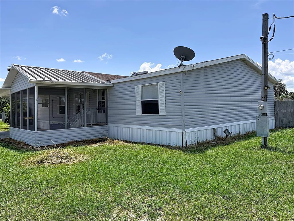 A light gray mobile home with a screened-in porch and a satellite dish on the roof — 4300 MEADOW RIDGE AVENUE, MULBERRY, FL