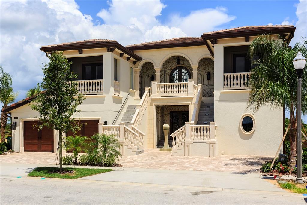 A two-story Mediterranean-style house with a raised entrance, double staircases, and a paved driveway — 905 GOLDEN BEAR DRIVE, REUNION, FL