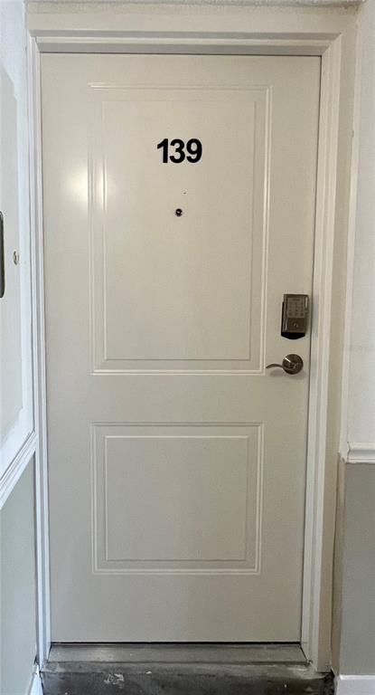 A white apartment door labeled with the number 139 features a digital keypad lock — 632 EDGEWATER DRIVE UNIT 139, DUNEDIN, FL