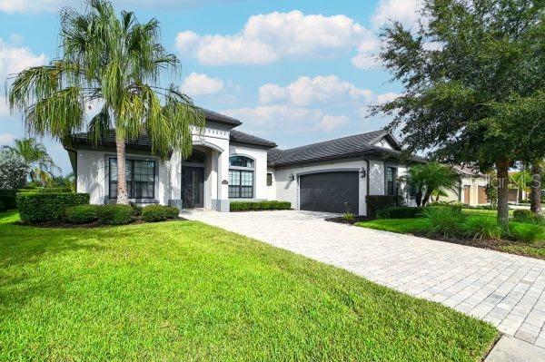 A single-story house with a paved driveway, a palm tree, and a two-car garage — 5507 ARNIE LOOP, LAKEWOOD RANCH, FL