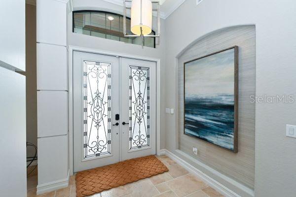 An entryway features double doors with decorative glass, a textured wall niche, and tile flooring — 5507 ARNIE LOOP, LAKEWOOD RANCH, FL