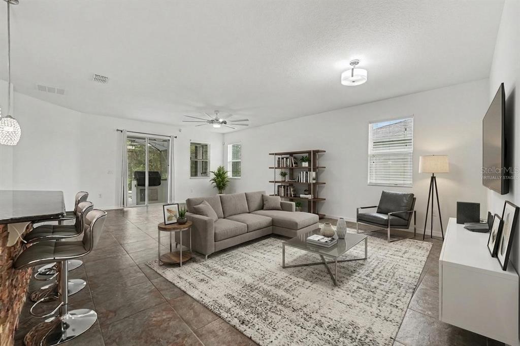 A living room with tile flooring, a sectional sofa, a coffee table, and a television — 2912 BOATING BOULEVARD, KISSIMMEE, FL