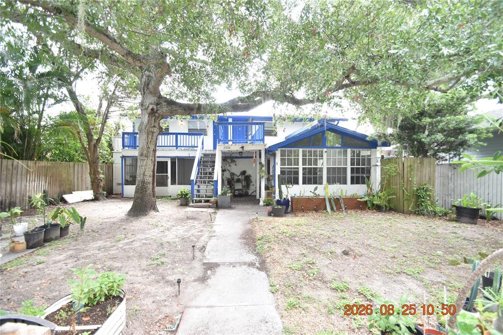 The exterior of a two-story house features a blue balcony, a staircase, and a yard — 2926 51ST STREET S UNIT 3, GULFPORT, FL