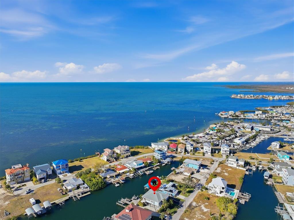 An aerial view shows a waterfront house with a red marker on a canal — 13875 HATCHER AVENUE, HUDSON, FL