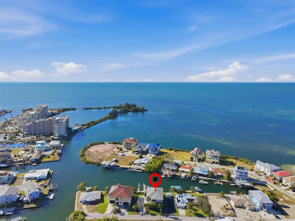 An aerial view shows a waterfront house with a boat dock on a canal — 13875 HATCHER AVENUE, HUDSON, FL