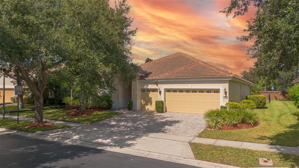 A single-story house with a tan stucco exterior, a tile roof, and a two-car garage — 524 DOUGLAS EDWARD DRIVE, OCOEE, FL