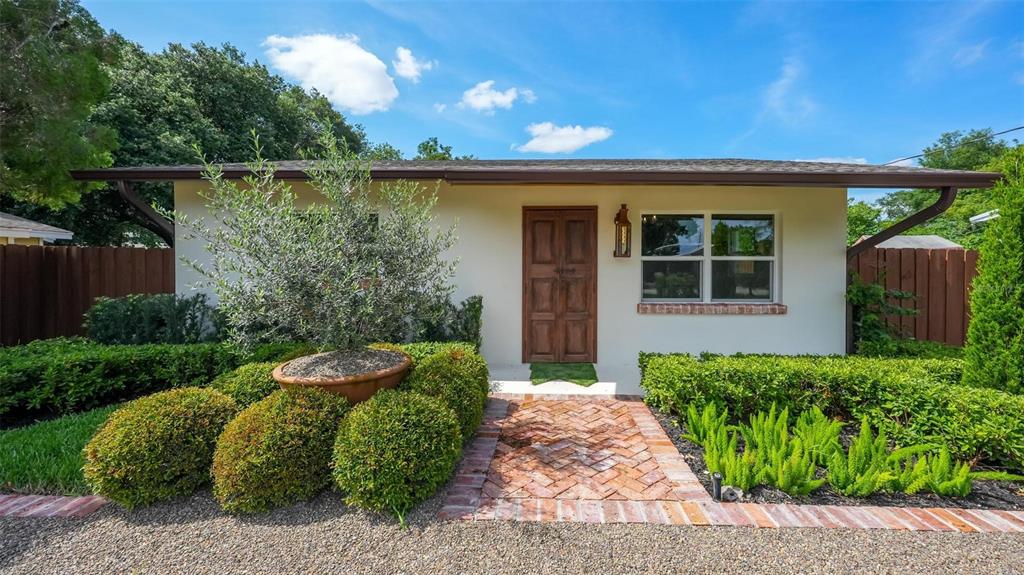 A single-story house with a brick walkway, a wooden front door, and manicured landscaping — 10541 3RD AVENUE, OCOEE, FL