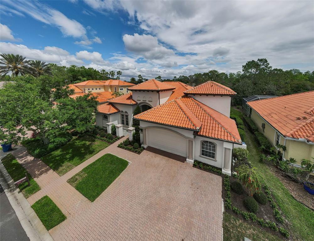 An aerial view of a single-story house with a tile roof and brick paver driveway — 1246 TUSCANY DRIVE, TRINITY, FL