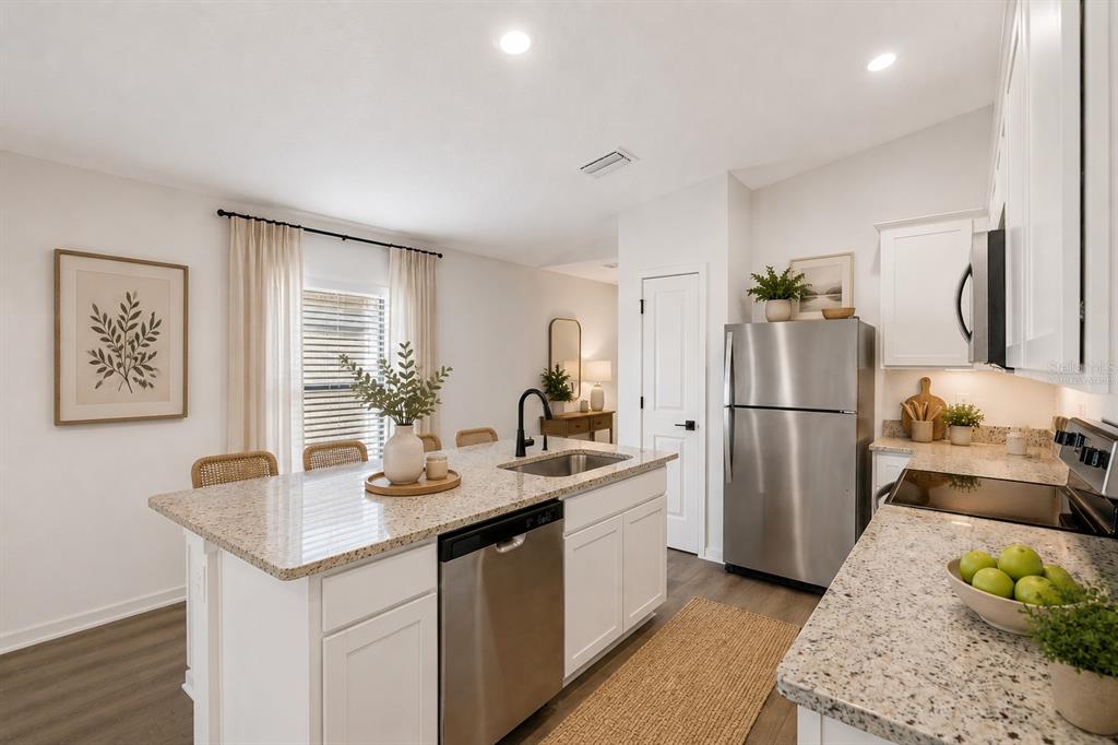 A kitchen features white cabinets, granite countertops, stainless steel appliances, and a central island — 5241 CAP ROAD, BROOKSVILLE, FL
