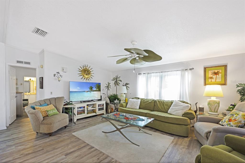A white manufactured home features a brick-paved driveway, a small palm tree, and landscaping — 2100 KINGS HIGHWAY UNIT 744, PORT CHARLOTTE, FL