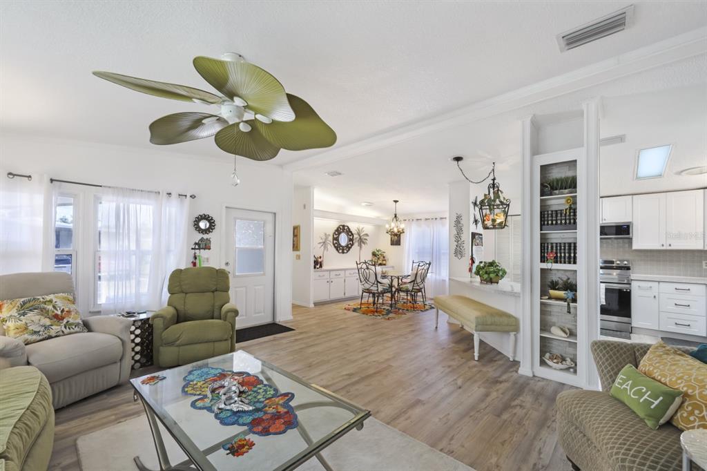 A screened-in porch is attached to the side of a white house with tall hedges — 2100 KINGS HIGHWAY UNIT 744, PORT CHARLOTTE, FL