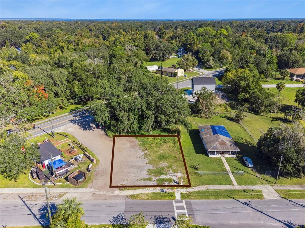 An aerial view shows a vacant rectangular lot bordered by a road and neighboring houses — 323 E FRANKLIN STREET, OVIEDO, FL