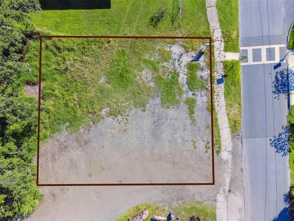 An aerial view shows a rectangular, mostly cleared vacant lot bordered by grass and trees — 323 E FRANKLIN STREET, OVIEDO, FL