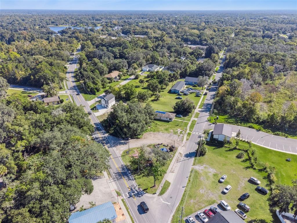 An aerial view shows a rural intersection with houses, trees, and a parking lot — 323 E FRANKLIN STREET, OVIEDO, FL