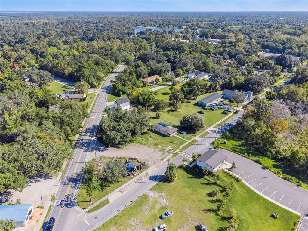 An aerial view shows a suburban intersection with houses, trees, and paved roads — 323 E FRANKLIN STREET, OVIEDO, FL