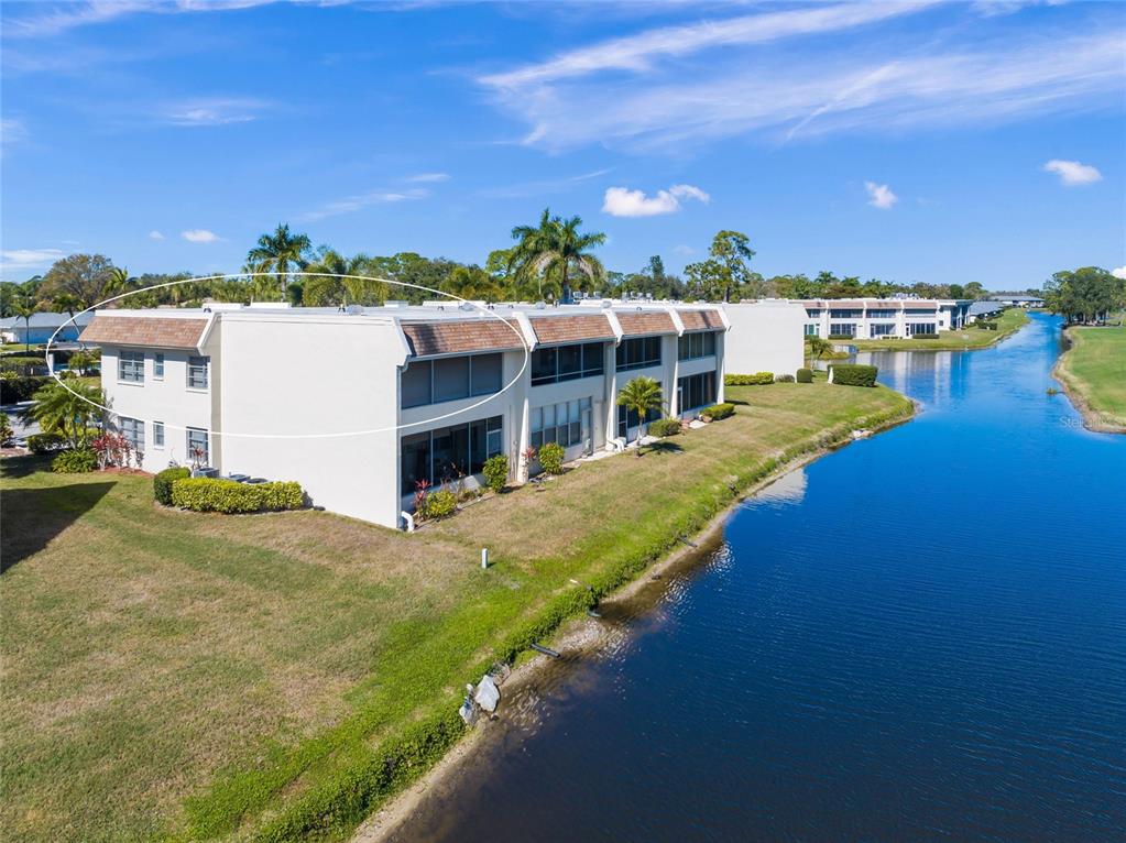 An exterior view of a multi-story waterfront condominium building with a circled roof section — 7193 W COUNTRY CLUB DRIVE N UNIT 237, SARASOTA, FL