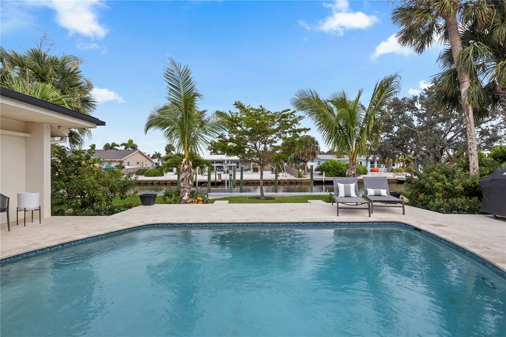 A single-story house with a metal roof and a paved driveway surrounded by landscaping — 624 DUNDEE LANE, HOLMES BEACH, FL