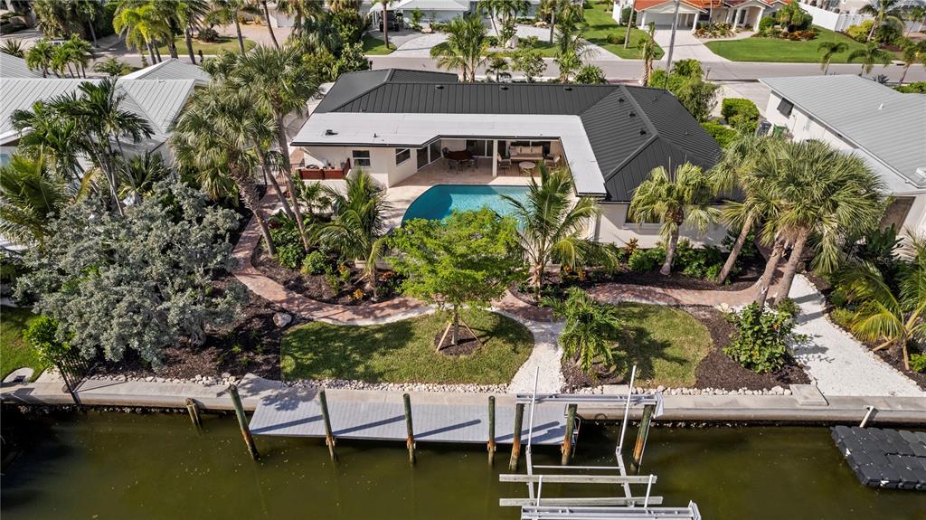 An aerial view shows a house with a metal roof, pool, and dock by water — 624 DUNDEE LANE, HOLMES BEACH, FL