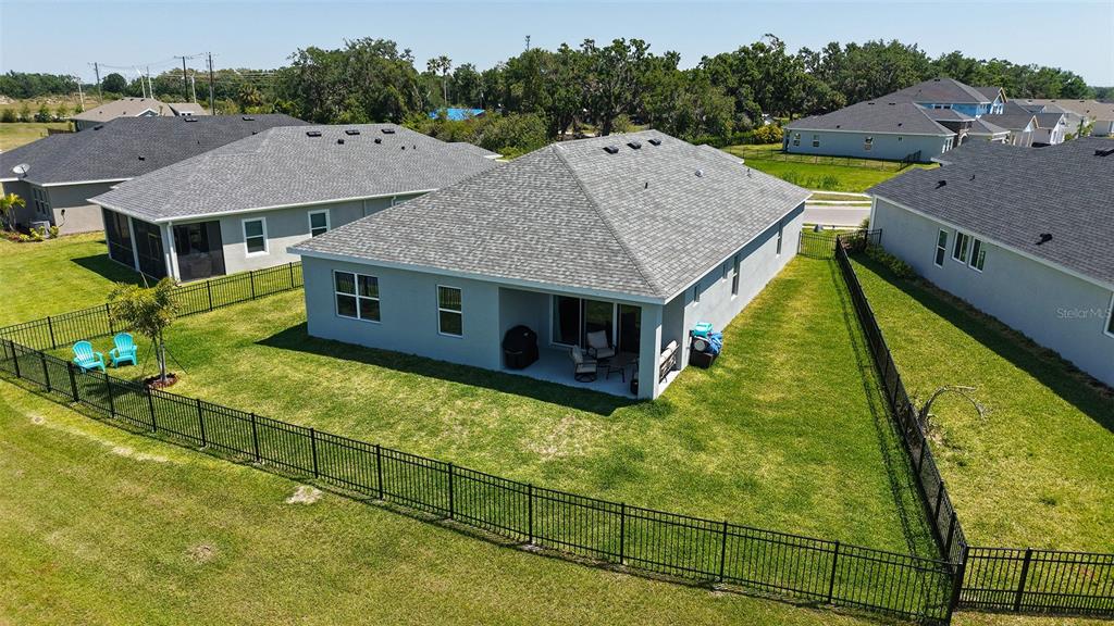 An aerial view of a gray house with a fenced backyard and a covered patio — 11869 RICHMOND TRAIL, PARRISH, FL