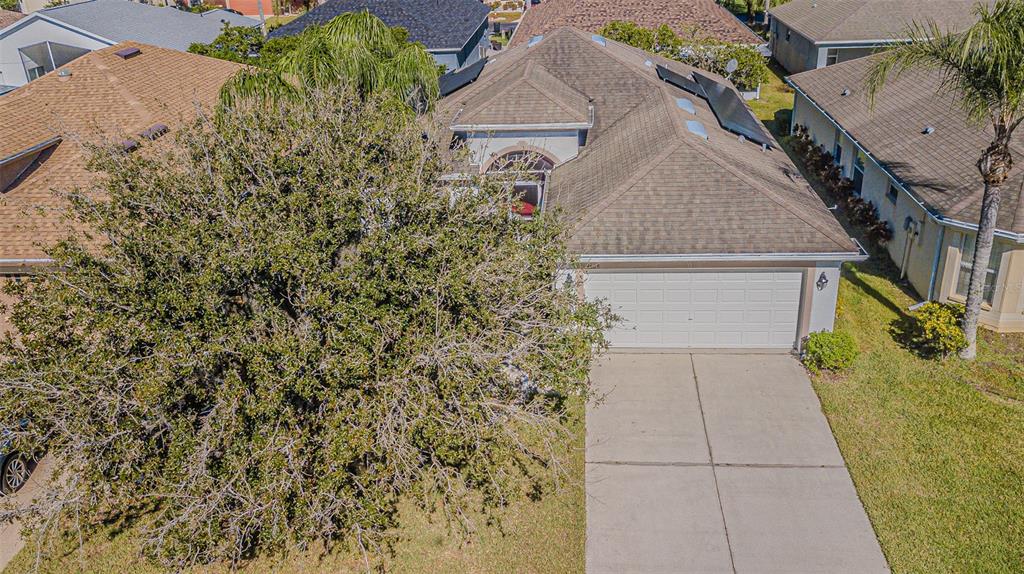 An aerial view shows a single-story house with a large tree in the front yard — 9608 ROLLING CIRCLE, SAN ANTONIO, FL