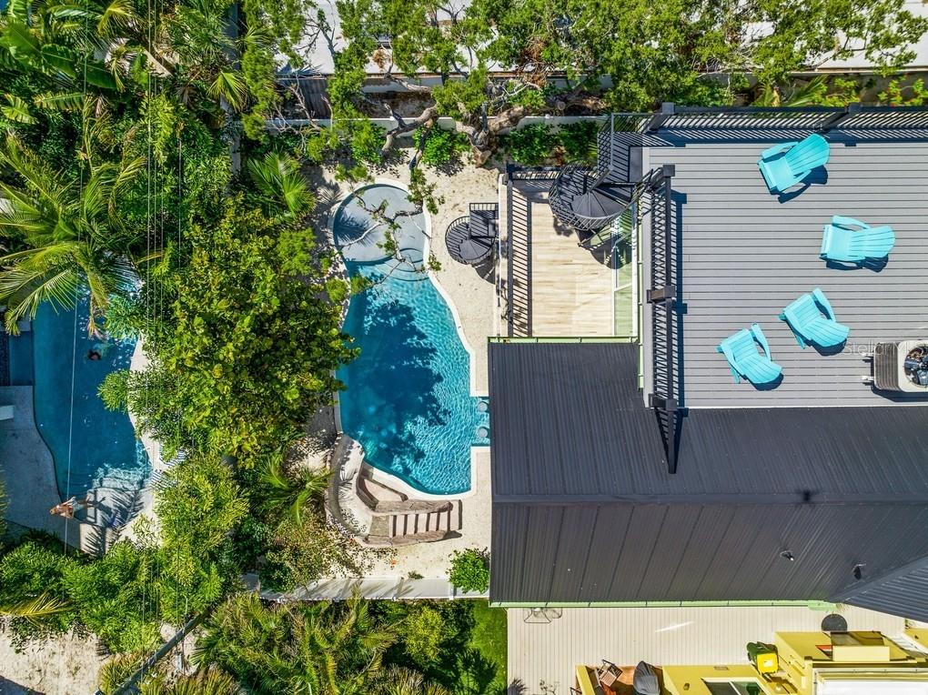 An aerial view shows a house with a metal roof, a rooftop deck, and a pool — 204 COOLIDGE DRIVE, SARASOTA, FL