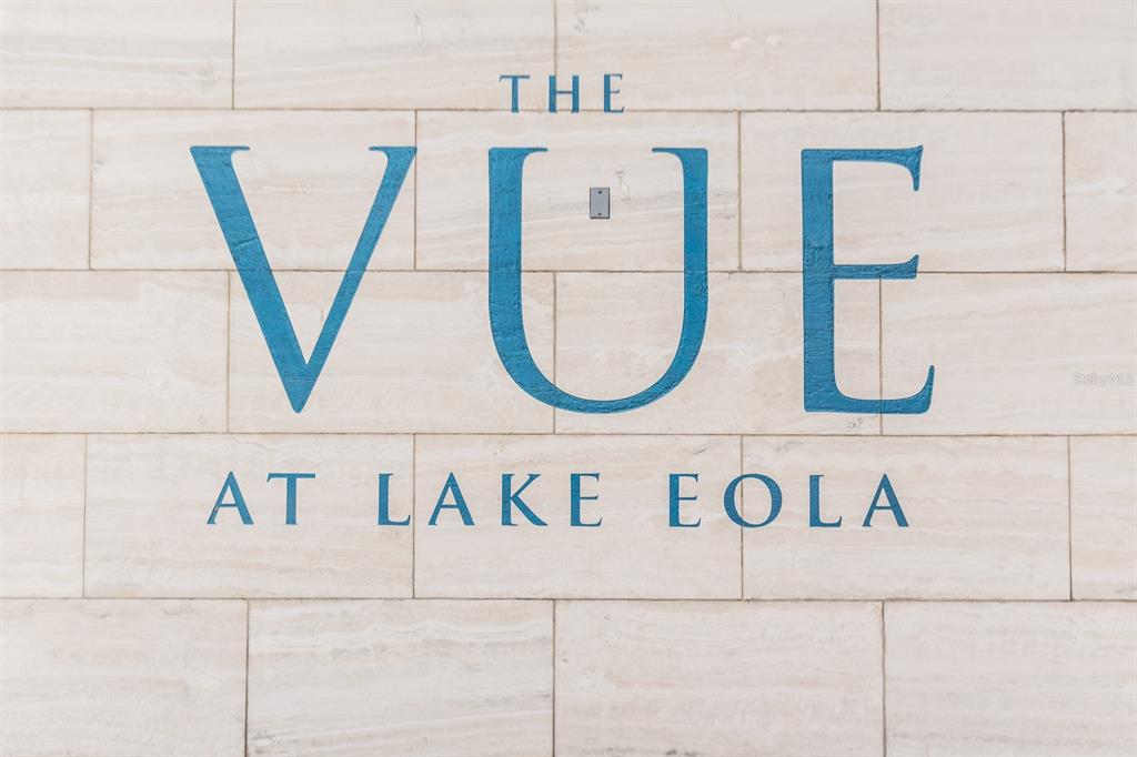 A blue sign reading The Vue at Lake Eola is mounted on a beige stone wall — 150 E ROBINSON STREET UNIT 2005, ORLANDO, FL