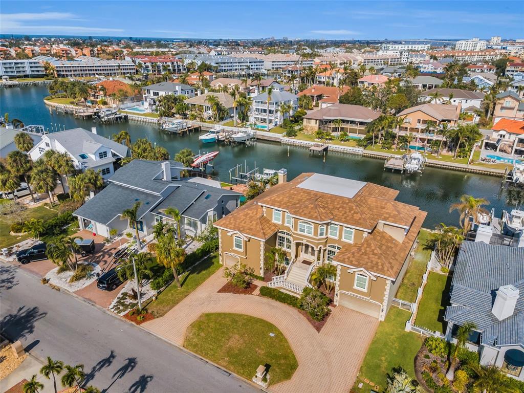 An aerial view shows a large brown house with a tiled roof near a canal — 119 8TH STREET E, TIERRA VERDE, FL