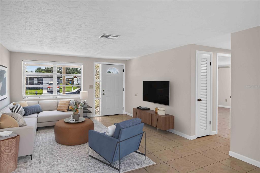A sunroom with sliding glass doors overlooking a lake, wicker furniture, and a beige rug — 2044 PAMELA DRIVE, HOLIDAY, FL
