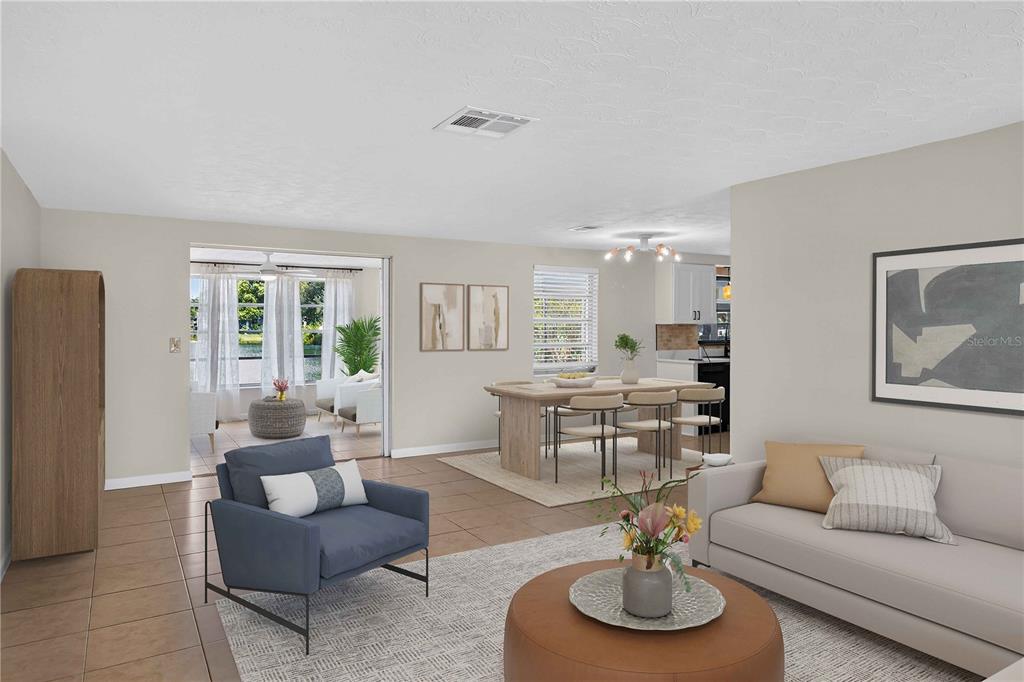 A living room features a sectional sofa, blue armchair, television, and tile flooring — 2044 PAMELA DRIVE, HOLIDAY, FL