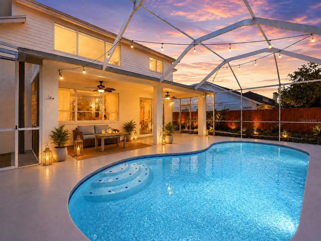 A backyard swimming pool with a screened enclosure, patio furniture, and a two-story house — 1610 LEDGESTONE DRIVE, BRANDON, FL
