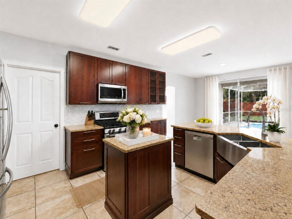 A two-story house with a beige stucco exterior, a two-car garage, and a palm tree — 1610 LEDGESTONE DRIVE, BRANDON, FL